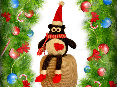 Sitzende Amigurumi-Eule mit roter Mütze, gestreiftem Schal und Herzapplikation auf Garnrolle