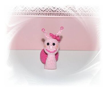 Kleine rosa Amigurumi-Schnecke mit Perlenfühlern und Schleife, Frontalansicht