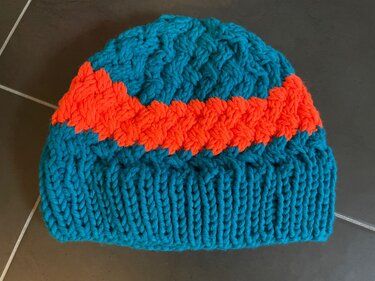Türkis‑orange Strickmütze mit Zopf- und Rippenmuster