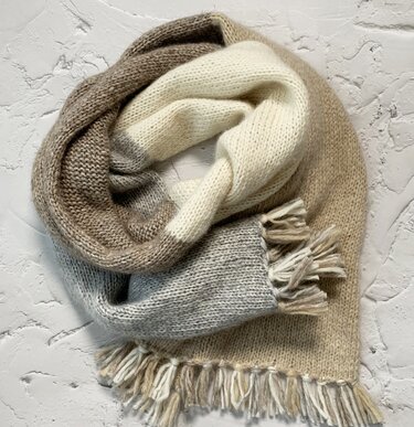 Mehrfarbiger gestrickter Loop-Schal in Beige, Creme und Hellgrau mit Fransen, aufgerollt