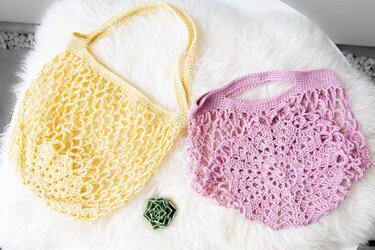 Gelbe und lila gehäkelte Netztaschen auf weißem Fell mit kleiner grüner Sukkulente