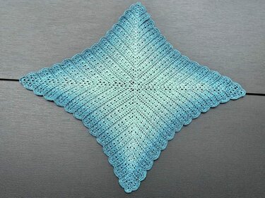 Gehäkeltes quadratisches Deckchen in Türkis-Mint mit Muschelrand, liegend in Raute