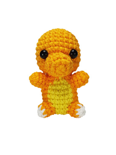 Gehäkeltes orange-gelbes Amigurumi-Drache mit schwarzen Augen und weißen Füßen vor weißem Hintergrund.