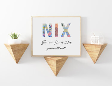 Gerahmtes Wandbild mit NIX aus Banknotenmotiven und dem Spruch „So, wie Du es Dir gewünscht hast“ an weißer Wand