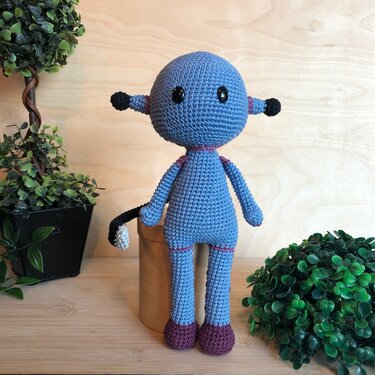 Vorderansicht einer gehäkelten Amigurumi-Puppe mit betonter Kopf-zu-Bein-Proportion