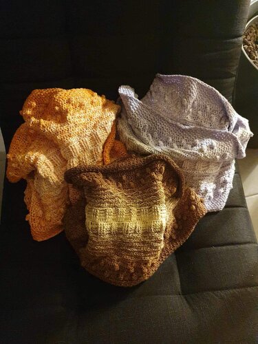 Drei gehäkelte Loop-Schals mit unterschiedlichen Mustern und Farbabstufungen