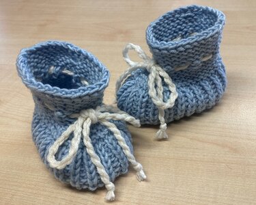 Nahaufnahme hellblauer Baby-Booties mit weißer Bindeschnur
