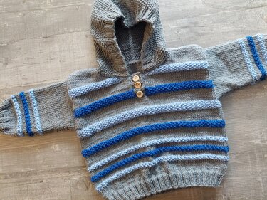Gestrickter grauer Kapuzenpullover mit hell- und dunkelblauen Streifen und drei Holzknöpfen