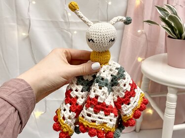 Gehäkeltes Schmusetuch mit Bommelkante und Amigurumi-Kopf, handgehalten