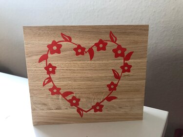 Quadratisches Holzschild mit großem roten Herz aus stilisierten Blumen und Blättern