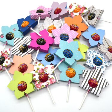 Nahaufnahme mehrerer bunter Blumen-Lutscher-Halter mit unterschiedlichen Mustern und Farben.