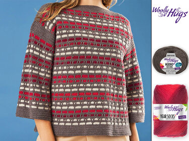 Gehäkelter Damenpullover mit Blockmuster in Rot, Cremeweiß und Grau; Garnknäuel daneben.