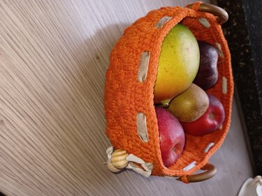 Kleiner runder Utensilo-Korb gehäkelt in Orange mit Holzringen und Band, gefüllt mit Obst