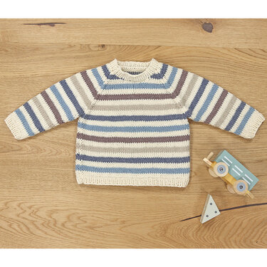 Gestrickter Kinderpullover in Creme mit blauen, grauen und braunen Streifen, flach auf Holzuntergrund
