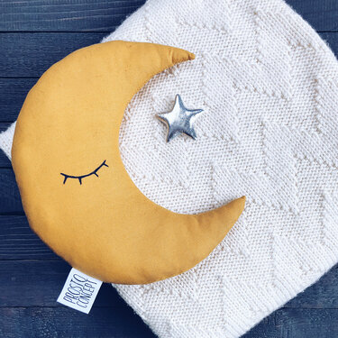 Mustard crescent moon pillow on ivory textured knitted baby blanket with small silver star