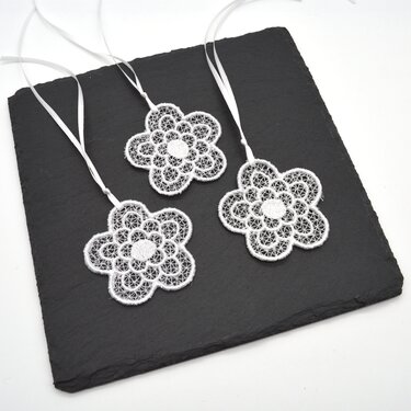Drei freistehende Spitzenblumen-Stickmotive mit Bändern