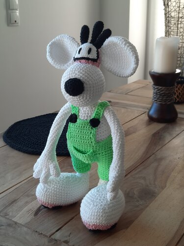 Amigurumi‑Maus mit getrennten angenähten Körperteilen, grüner Latzhose und schwarzen Details