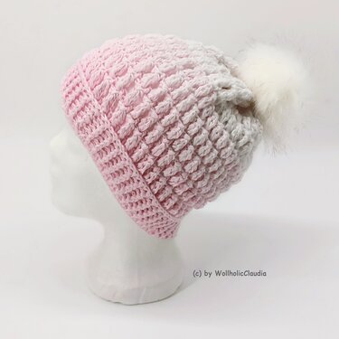 Pastellrosa gehäkelte Mütze mit voluminösem weißen Bommel, Seitenansicht