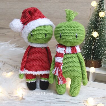 Zwei gehäkelte grüne Amigurumi, links mit rotem Nikolauskostüm, rechts mit rot-weiß gestreiftem Schal und Haarschopf