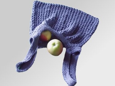 Violetter gestrickter Beutel mit zwei Äpfeln
