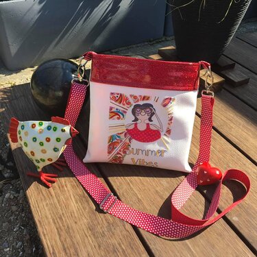 Weiße Umhängetasche mit rotem Glitzerabschluss, farbenfrohem Summer-Vibes-Motiv, gepunktetem Tragegurt, Herzanhänger und dekorativer Hühnerfigur