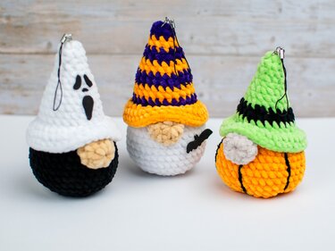Nahaufnahme von drei gehäkelten Halloween-Wichteln mit Aufhängern für Schlüsselanhänger oder Dekoration.