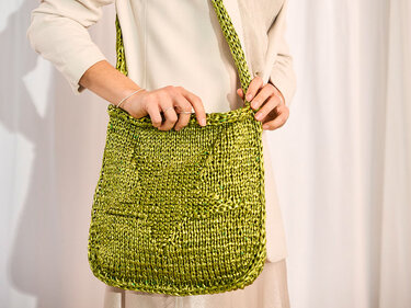 Olivgrüne, grob gestrickte Schultertasche mit Sternmotiv und langem Riemen