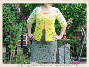 Frau trägt gelb-grüne gehäkelte Sommerjacke mit 3/4-Ärmeln und Lochmuster