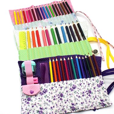 Geöffnete, farbenfrohe Stifterolle aus Stoff mit Buntstiften und Zubehör