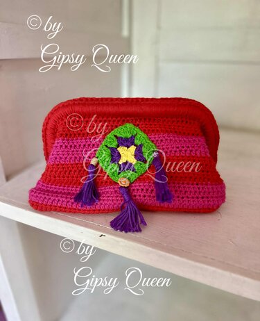 Rote und pinke gehäkelte Clutch mit grünem Granny
Square und violetten Quasten