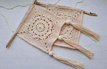 Boho-Wandbehang aus zwei gehäkelten Granny-Motiven mit Quasten und Holzperlen an einem Ast