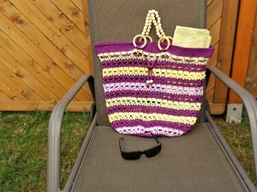 Gehäkelter Shopper in Lila, Gelb und Lavendel auf Liegestuhl