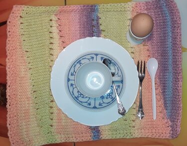 Rechteckiges gestricktes Platzset in Pastell mit Teller, Besteck und Eierbecher