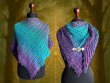 Zwei Schaufensterpuppen mit gehäkelten Dreieckstüchern in Türkis und Violett, eines mit metallener Tuchspange