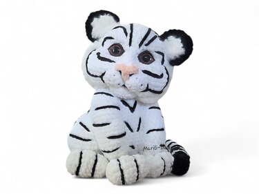 Seated crocheted white tiger amigurumi with black stripes and pink nose