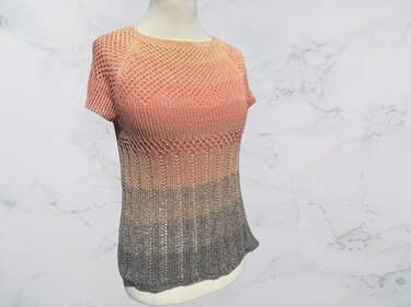 Damen Kurzarm‑Strickshirt mit Pfirsich‑zu‑Grau Farbverlauf und Strukturmuster auf Schaufensterpuppe