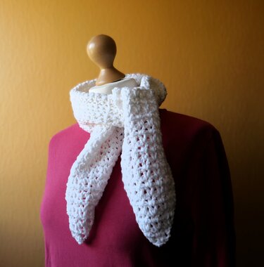 Weißer gehäkelter Schal mit Lochmuster um eine Schaufensterpuppe gelegt