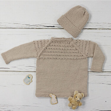 Beiger gestrickter Babypullover mit Lochmuster und passender Mütze auf hellem Holzuntergrund