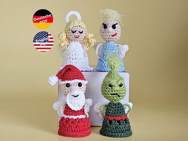 Vier kleine, gehäkelte Amigurumi-Figuren: ein Engel mit Heiligenschein, ein blau gekleidetes Teufelchen, ein Weihnachtsmann mit Bart und ein grünes Monster.