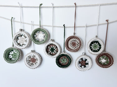 Small beaded crochet ornaments in green, brown and white strung on a cord