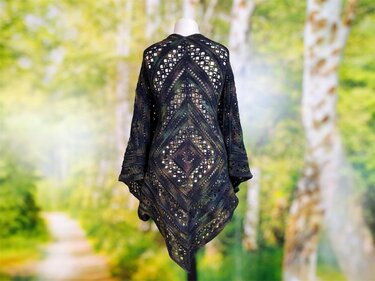 Dark crochet lace shawl with central diamond motif and pointed hem on a mannequin