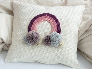 Crochet pattern cushion with rainbow appliqué for the children's room