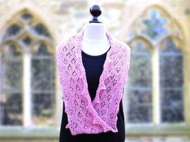 pink lace knit cowl with ruffled edge on mannequin