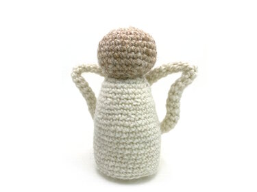 Crocheted amigurumi angel in cream yarn with beige head and looped wings