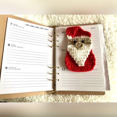 Gehäkeltes Nikolaus-Lesezeichen liegt auf geöffnetem Ringbuch-Planer