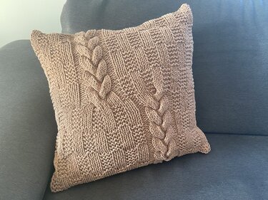 Quadratischer Kissenbezug in Taupe mit zwei Zopfreihen und kariertem Strukturmuster