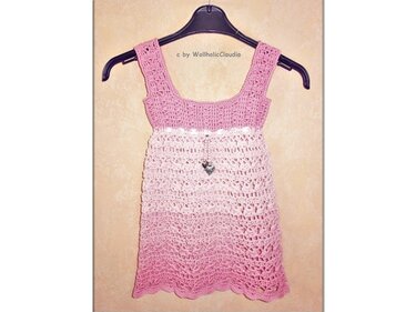 Gehäkeltes rosa Mädchenkleid mit Ombré-Farbverlauf an Kleiderbügel