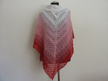 Gestricktes dreieckiges Lacetuch mit Farbverlauf von Weiß über Rosa zu Rot auf einer Schneiderpuppe.