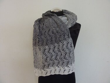 Gestrickter Ajour‑Schal mit Grau‑Weiß‑Verlauf auf Schneiderbüste