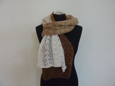 Dreifarbiger Strickschal in Naturtönen mit feinem Ajourmuster an einer schwarzen Schaufensterpuppe.